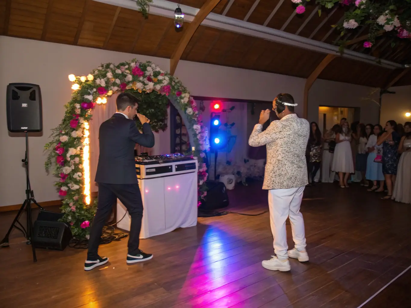 A vibrant image capturing Annie Vegas in action at a wedding reception, skillfully transitioning between songs on her DJ equipment, with guests joyfully dancing in the background, bathed in soft, romantic lighting.